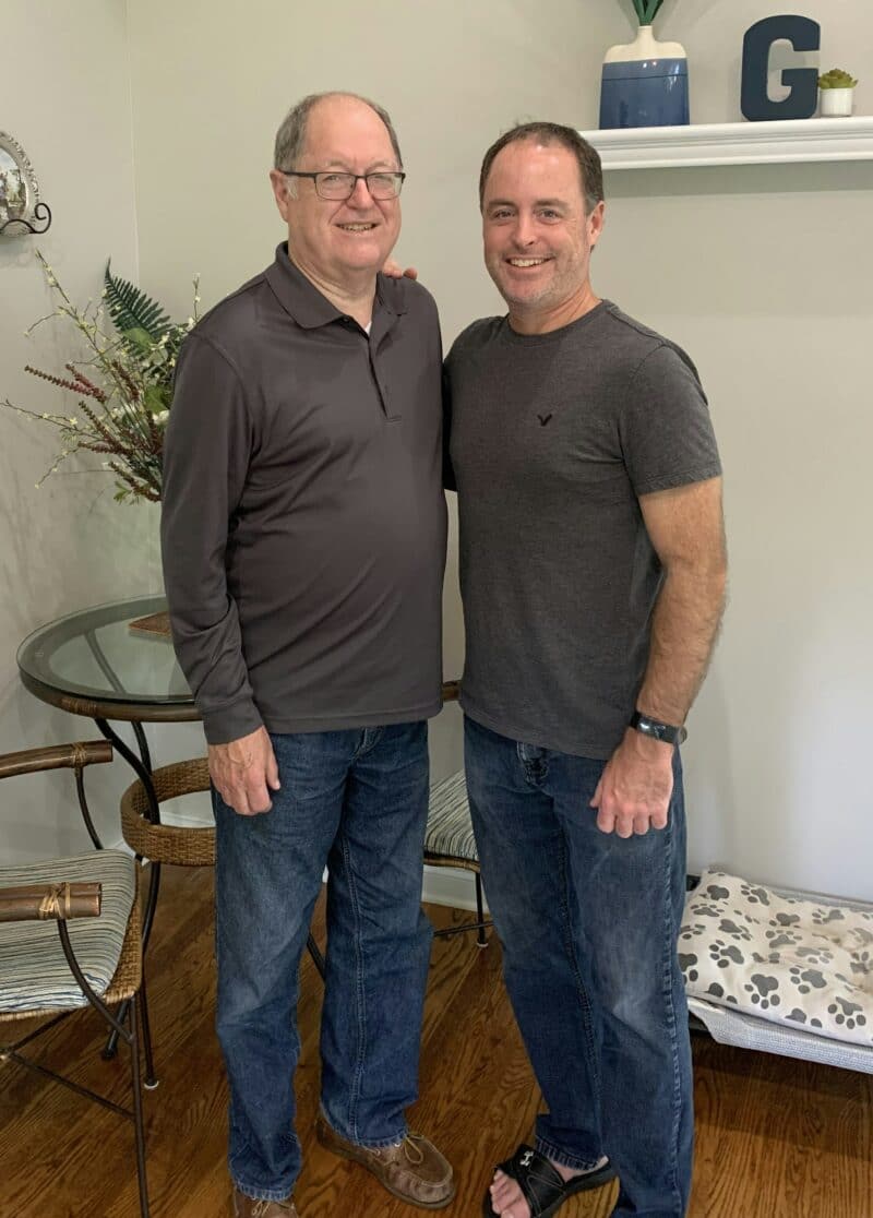 Father and son matching gray shirts with blue jeans smiling