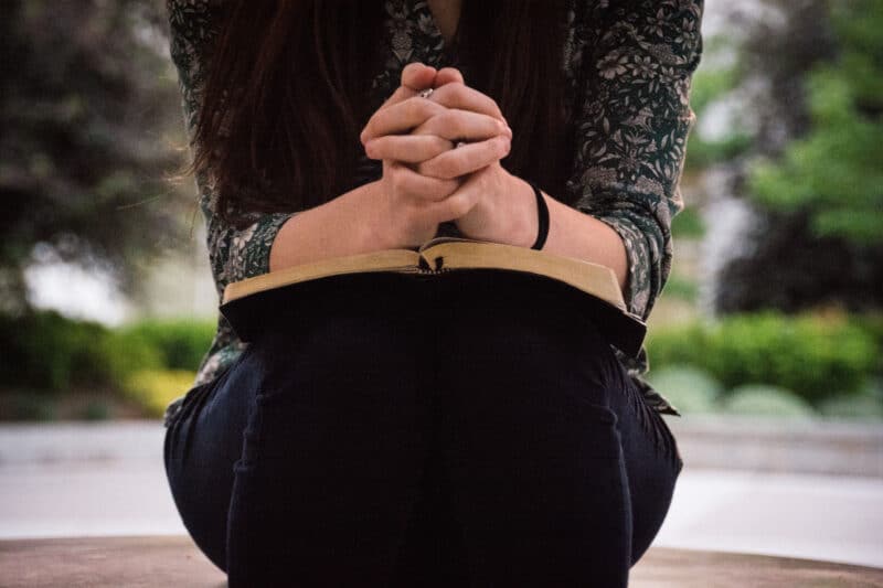 woman holding bible praying