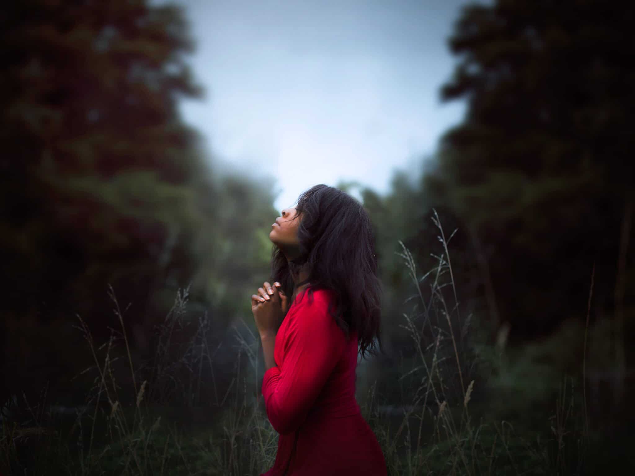 woman praying in trees looking up to sky