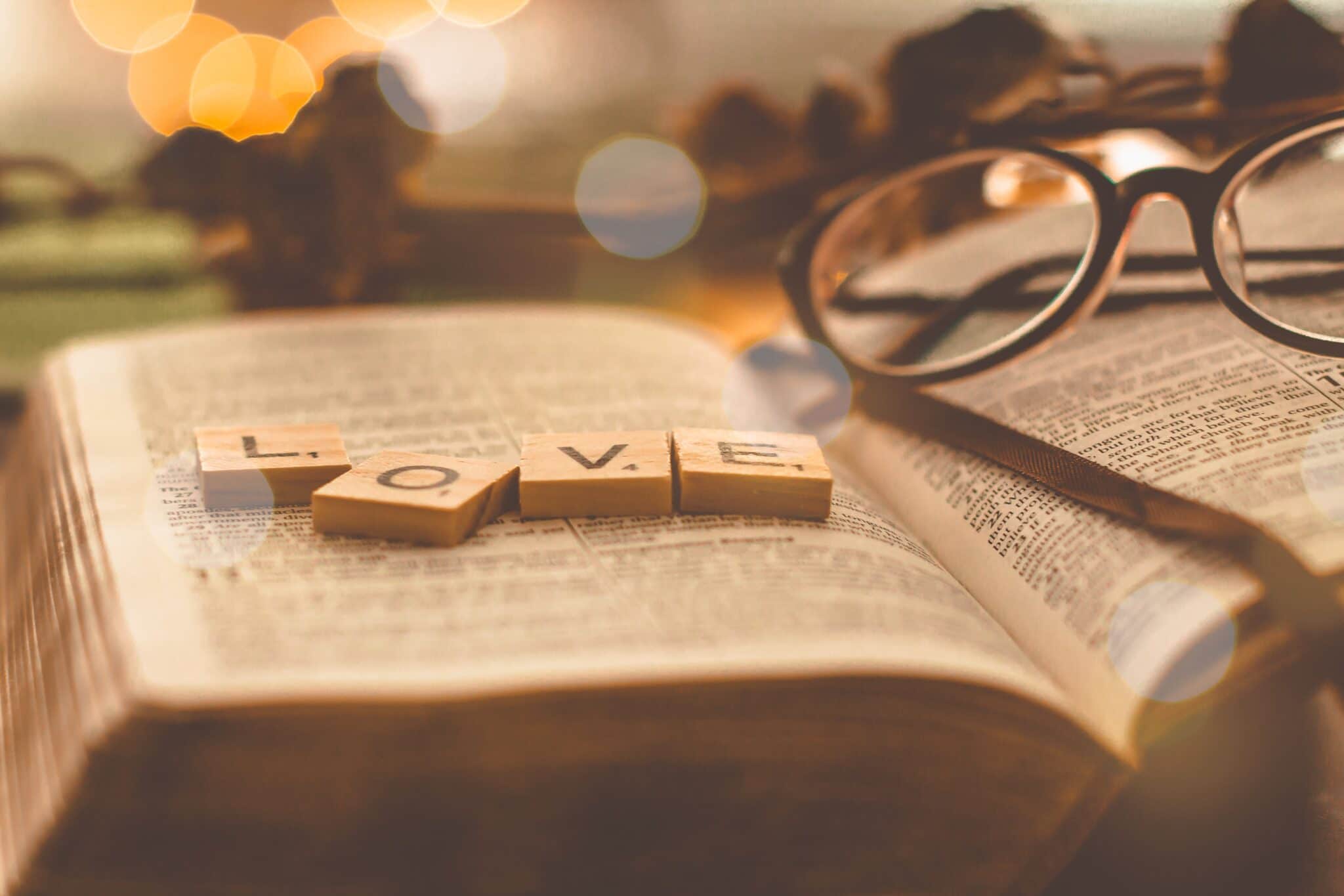 Bible with glasses and love tiles on top