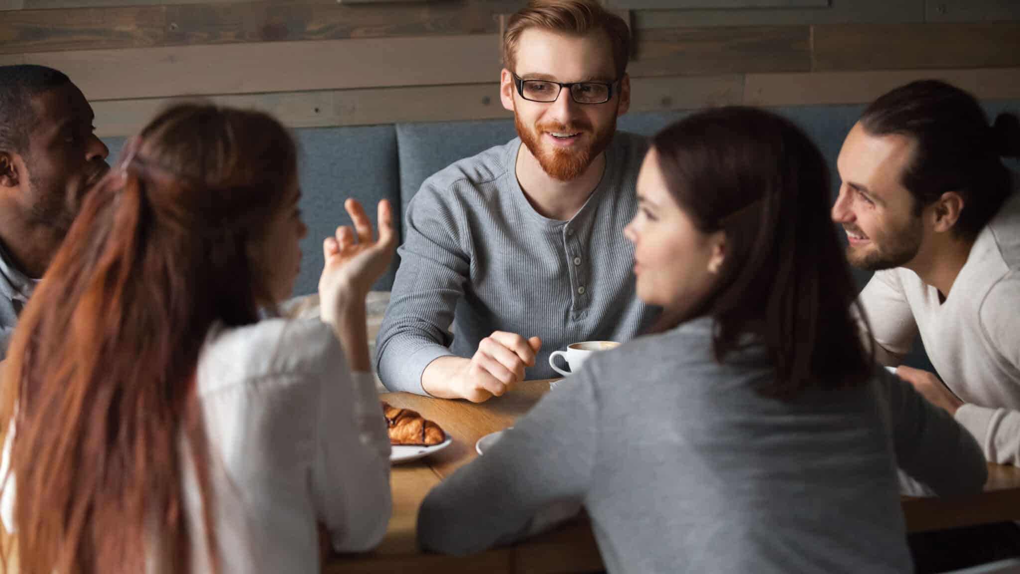 people talking and eating at a table