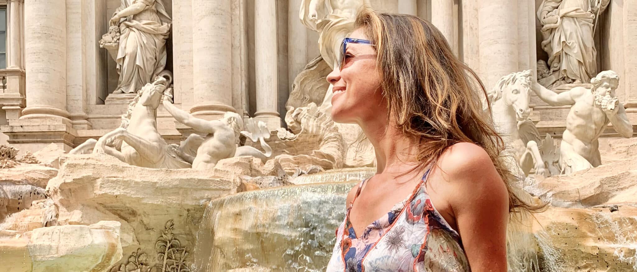 Woman sitting in front of fountain in Italy.
