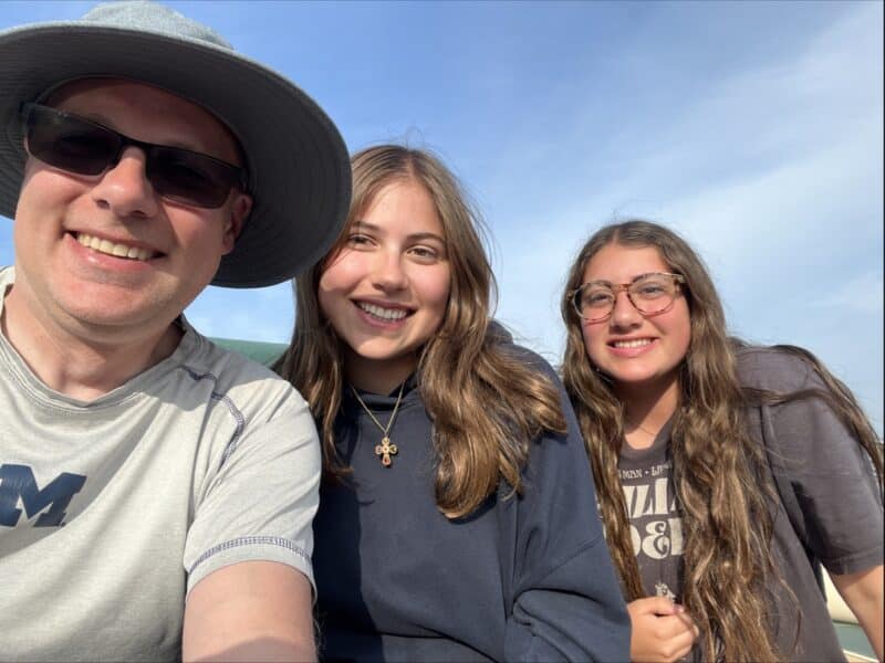 Father with 2 daughters smiling and happy.