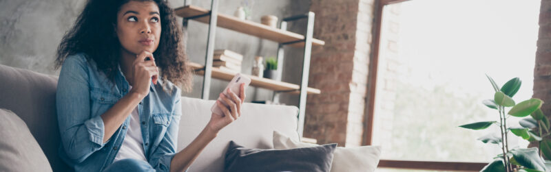 Photo of lady sitting on couch holding phone