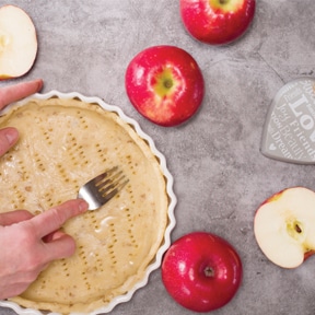 person pressing crust into pie plate for apple pie