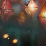 Gold, red and blue hanging lanterns with yellow christmas lights.