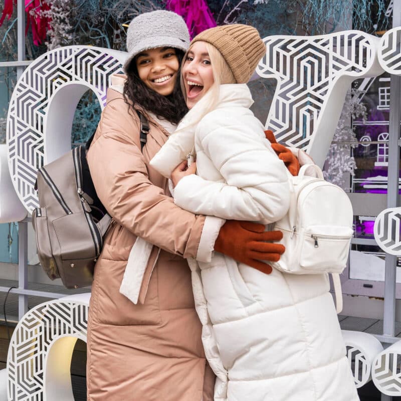 friends standing in front of the word LOVE at christmas