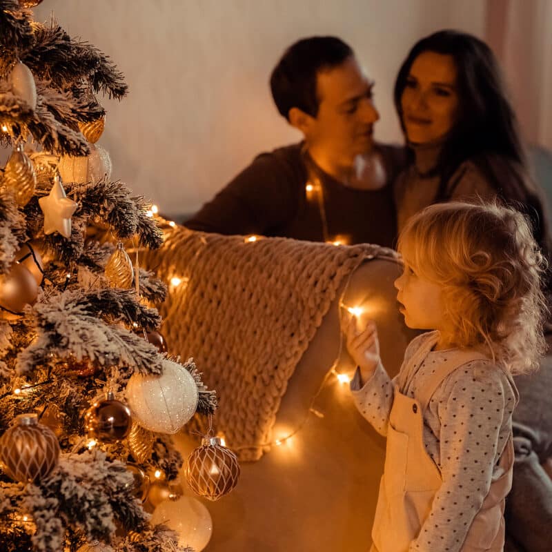 family looking at christmas tree lights